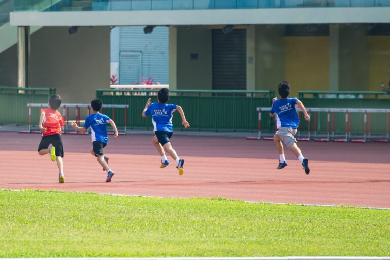 Four boys in PE uniforms racing on track